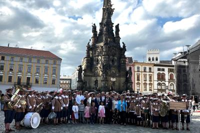 Die offizielle Delegation, angeführt von Oberbürgermeister David Wittner mit der Knabenkapelle Nördlingen vor der Dreifaltigkeitssäule (UNESCO-Weltkulturerbe) auf dem Marktplatz der Partnerstadt Olomouc.