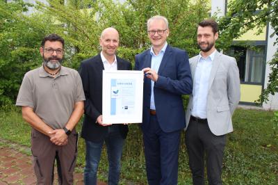 IHK-Regionalgeschäftsführer für den Wirtschaftsraum Augsburg, Jens Walter (Zweiter von rechts), überreichte (von links) Paul Pirisino, Stefan Reitsam und Fabian Malz (alle Bezirkskliniken Schwaben) die EMAS-Urkunde. 