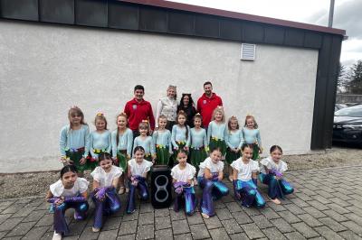 Auf dem Bild sind hinten v. l. n. r. Christian Baur (1. Vorstand der Rot-Weissen-Burgstädter e. V.),  Meike Jörg und Alina Schmidt (Trainerinnen der Just Dance Tanzgruppen) und Martin Müller (2.  Vorstand der Rot-Weissen-Burgstädter e. V.). In den vorderen beiden Reihen sind Tänzerinnen der  Just Dance Minis und Kids zu sehen