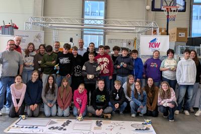 Schülerinnen und Schüler der Mittelschule sowie (v.l.n.r.) Luca Kienzle und Peter Eichbauer (Technologie Centrum Westbayern GmbH) Armin Richters von der Magdalene-Armin-Richters-Stiftung, Ronny Birzele (Lehrer der Mittelschule Nördlingen), Michael Enslin, Amèlie Franken von der ITQ GmbH (Gerda Stetter Stiftung – Technik macht Spaß) und Marco Mayer (Schwaben Präzision) in der TCW-Robotik Halle vom Technologie Centrum Westbayern.