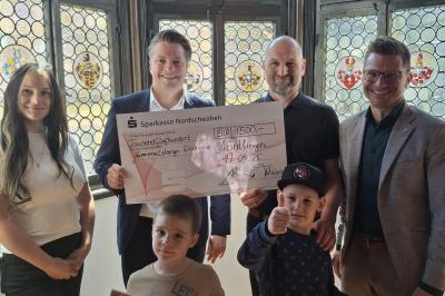Spendenübergabe im Nördlinger Rathaus: Tobias Güntner (2. v. l.) und Oberbürgermeister David Wittner (1. v. r.) überreichen den symbolischen Scheck über 1.500 Euro an Wolfgang Salcher (2. v. r.), Nadja Goß (1. v. l.) sowie zwei Kinder aus der Einrichtung.