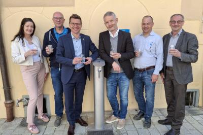 Probierten das erste Wasser aus dem neuen Trinkbrunnen vor der Tourist-Information: (v. l. n. r.): Martina Schwarzer (Werkleiterin Stadtwerke), Peter Ringle (BEULCO GmbH & Co. KG), Oberbürgermeister David Wittner, Andreas Wagnleitner (Geschäftsführer Eisen-Fischer GmbH), Frank Schmidtkunz (Wassermeister Stadtwerke) und Martin Bickelein (Technischer Werkleiter Stadtwerke). Der Trinkwasserbrunnen steht der Öffentlichkeit ab sofort zur kostenfreien Nutzung zur Verfügung.