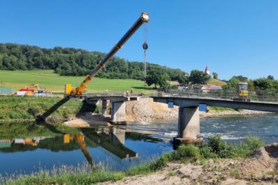 Das Foto zeigt die Bauarbeiten an der alten Donaubrücke in Schäfstall mit dem Rückbau der Überbauplatte. Das mittlere Segment ist bereits teilweise ausgehoben.  