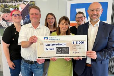 Bankvorstand Dr. Walter Greiner (rechts) von den Genossenschaftsbanken im Landkreis übergab 3000 Euro an die Liselotte-Nold-Schule: vlnr Stephanie Lange, Pfarrer Dr. Philipp Beyhl für den Träger, Verwaltungsleiterin Evelyn Dähn, Schulleiterin Waltraud Bergmaier und Rebecca Parentin