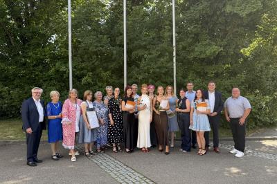 Nach der Übergabe der Gesellenbriefe tragen sich die frischgebackenen Gesellinnen mit den Ehrengästen zum Gruppenbild.