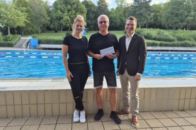 Ein besonderer Freibadbesuch: Günter Leeder aus Reimlingen wurde als 111.111. Badegast der diesjährigen Saison begrüßt. Zum besonderen Jubiläum gratulierten Nicole Hoffmann (Bäderteam, links) und Oberbürgermeister David Wittner (rechts) und überreichten ihm einen Gutschein für das „kraterbad“.