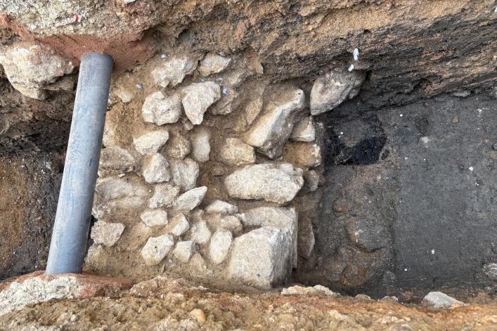 Die gefundene Mauer samt dem Rest des Holzpflocks (dunkle Stelle rechts oben neben der Mauer)