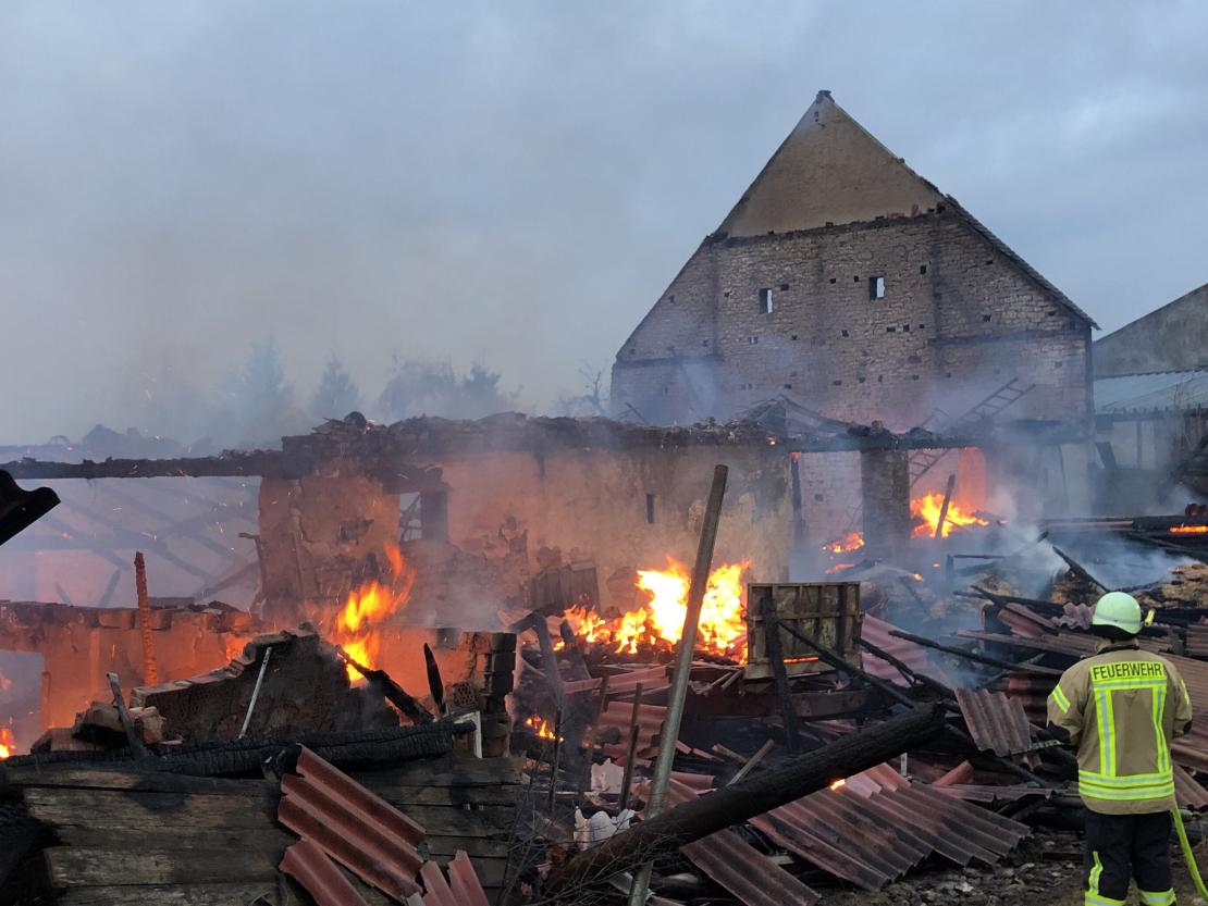 Die Feuerwehr kämpft noch immer gegen die Flammen in dem völlig zerstörten Hof. 