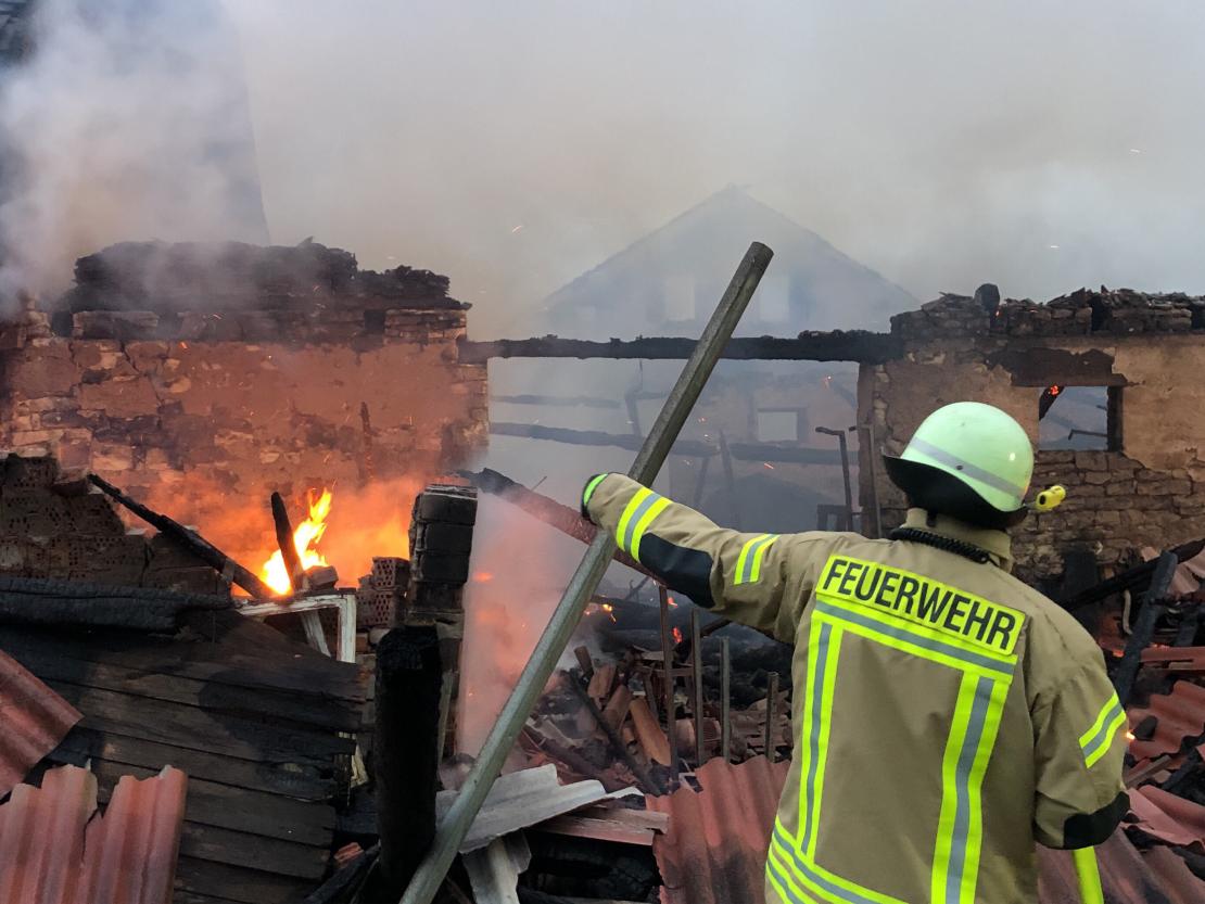 Feuerwehrleute kämpfen gegen den Brand in einem Landwirtschaftlichen Anwesen.