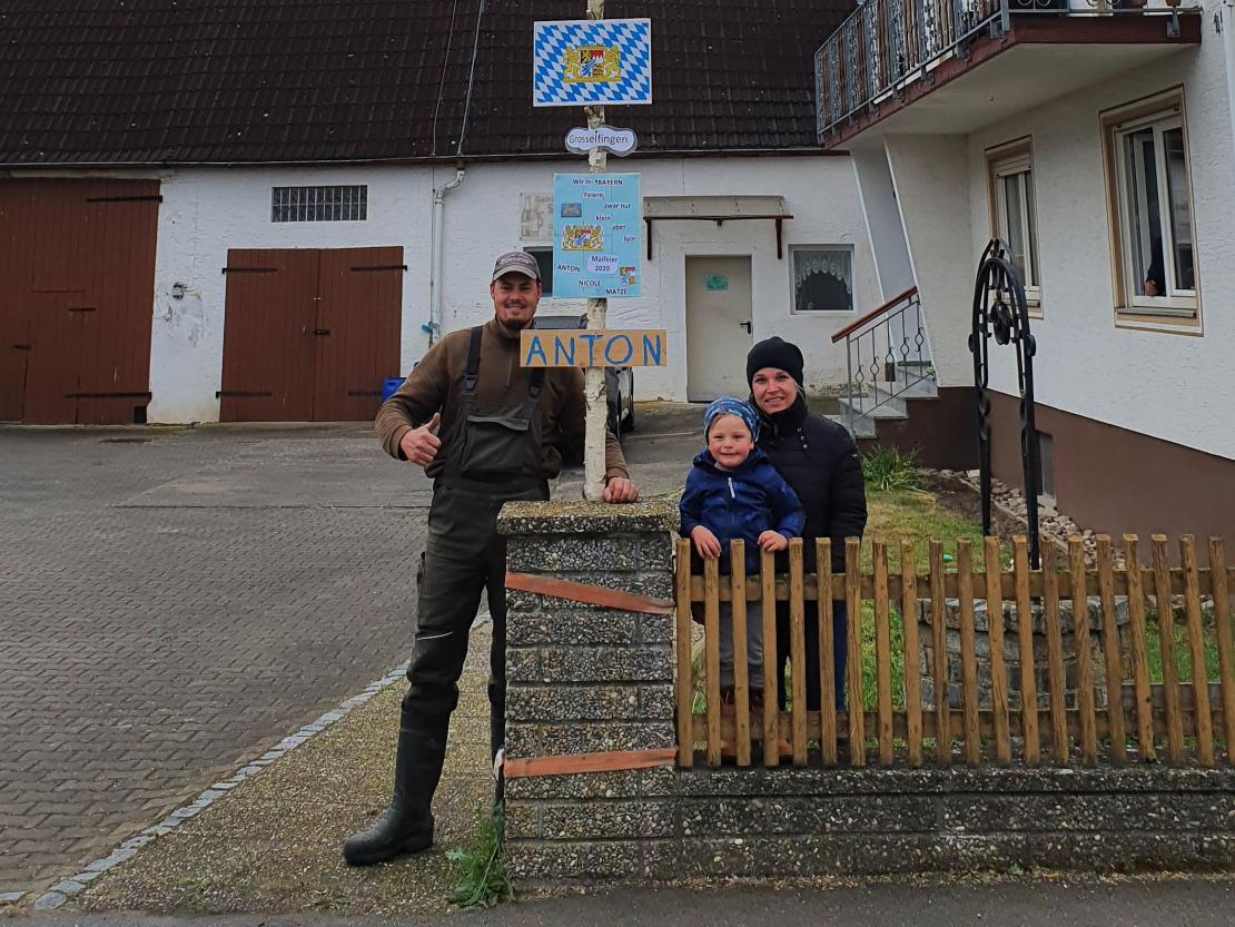 Mann, Frau und Kind mit Maibaum