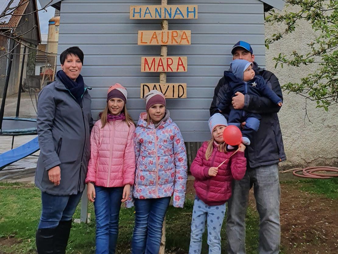 Mann und Frau mit vier Kindern und Maibaum