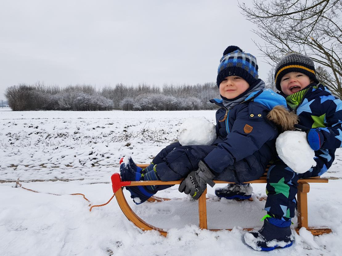 Das Bild zeigt Kinder auf einem Schlitten.
