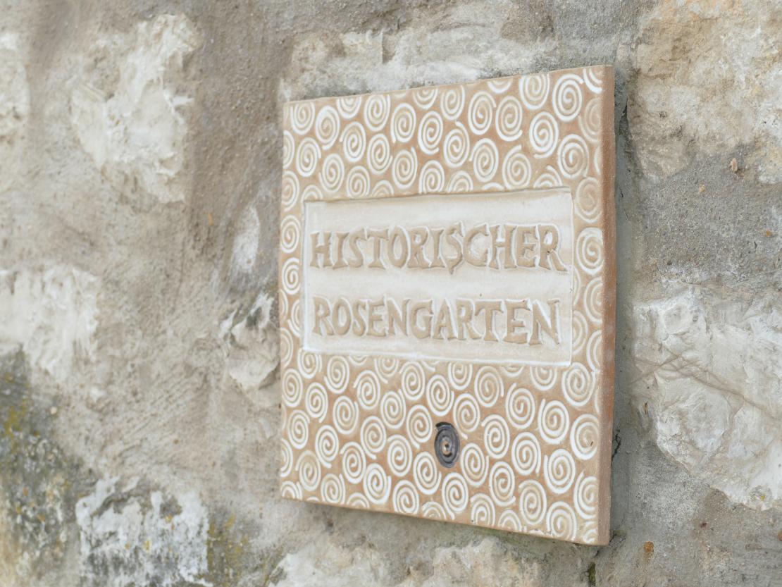 Damit man das Paradies auch gut findet, hängt davor eine lieblich verzierte Steintafel, die nicht zu verfehlen ist. 