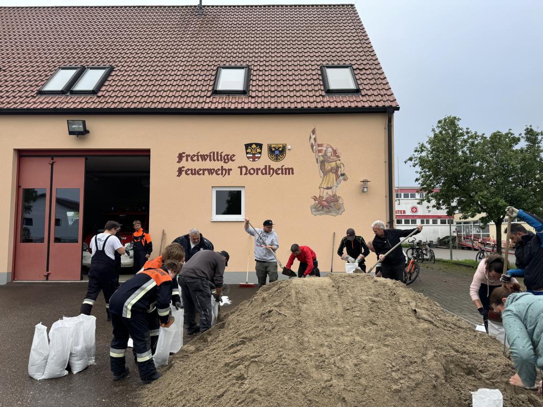 Freiwillige Helfer füllen in Nordheim Sandsäcke.