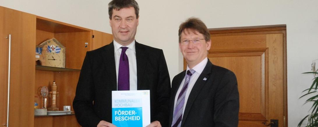 Markus Söder übergibt einen Förderbescheid in Höhe von 2,1 Millionen Euro an den Landrat Stefan Rößle. (Bild: Mara Kutzner)