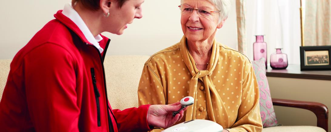 Hausnotruf-Kundenberaterin erklärt das Gerät