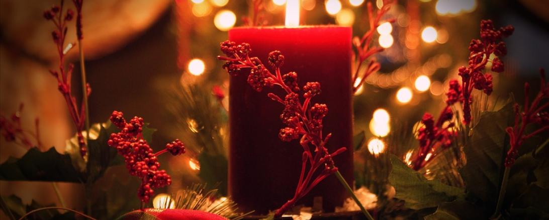 Das Bild zeigt eine Kerze mit Weihnachtsdeko