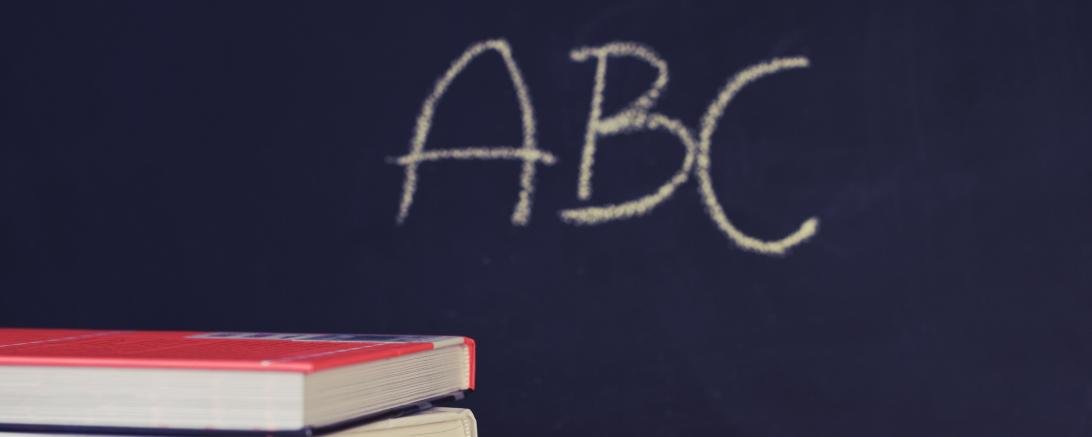 Das Bild zeigt Bücher, Kreide, Tafel