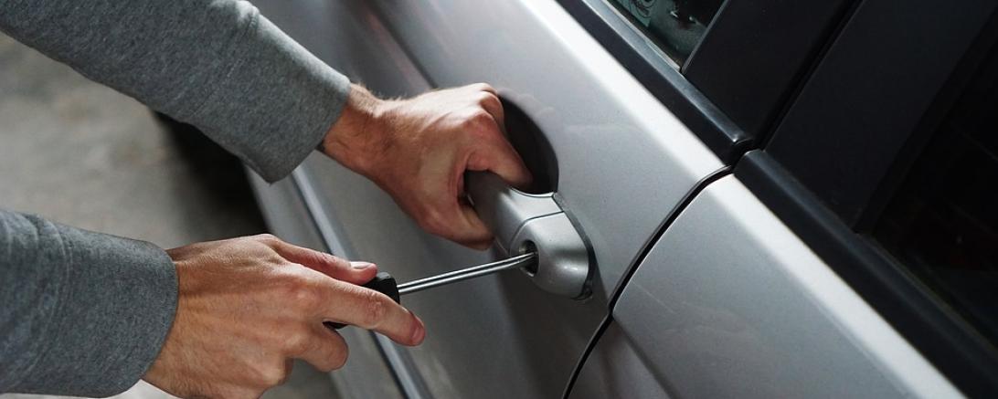 Das Bild zeigt, wie ein Pkw aufgebrochen wird. 