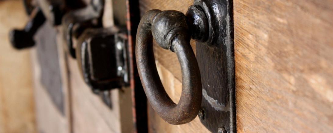 Das Bild zeigt eine massive Holztür. 