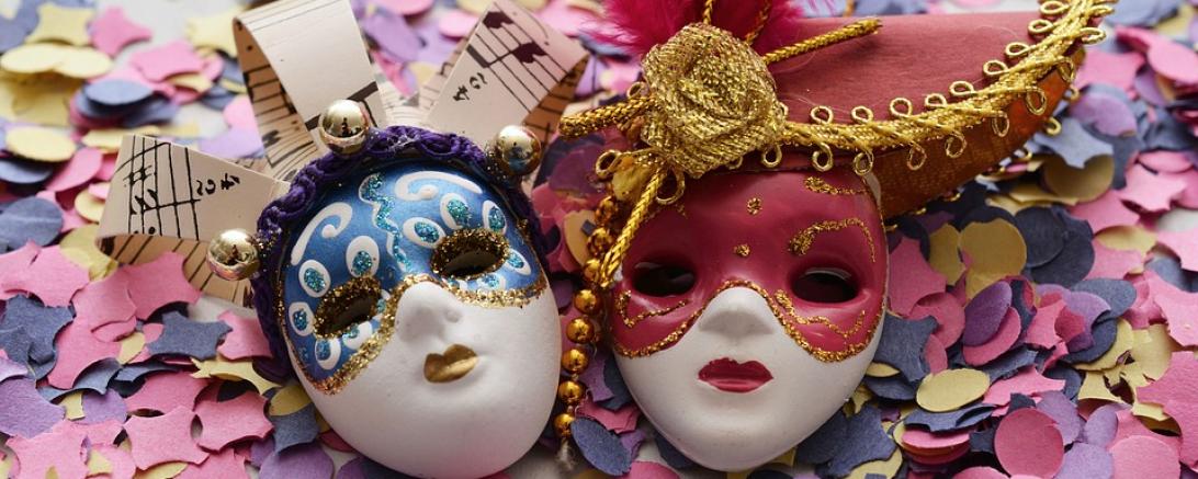 Das Bild zeigt zwei Karneval Masken und Konfetti.