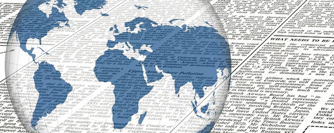 Das Bild zeigt eine Weltkugel und einen Zeitungsartikel. 