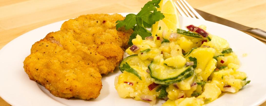 Das Bild zeigt ein Schnitzel mit Kartoffelsalat. 