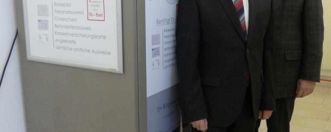 Bürgermeister Georg Vellinger, Vorsitzender der Verwaltungsgemeinschaft Monheim, und Bürgermeister der Stadt Monheim, Günther Pfefferer, vor dem neuen Passbildautomaten