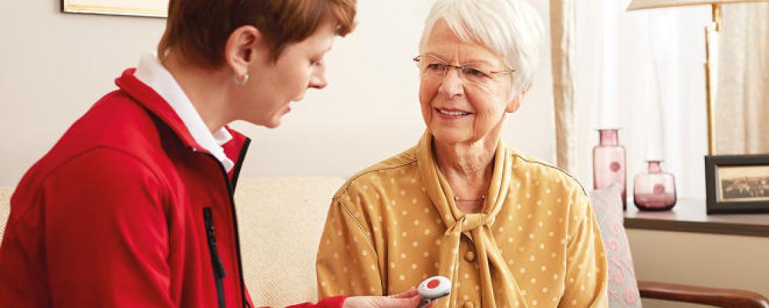 Hausnotruf-Kundenberaterin erklärt das Gerät