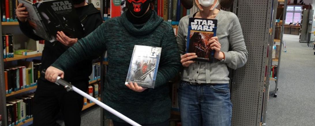 Bibliotheksteam mit Masken aus Star Wars -Episoden