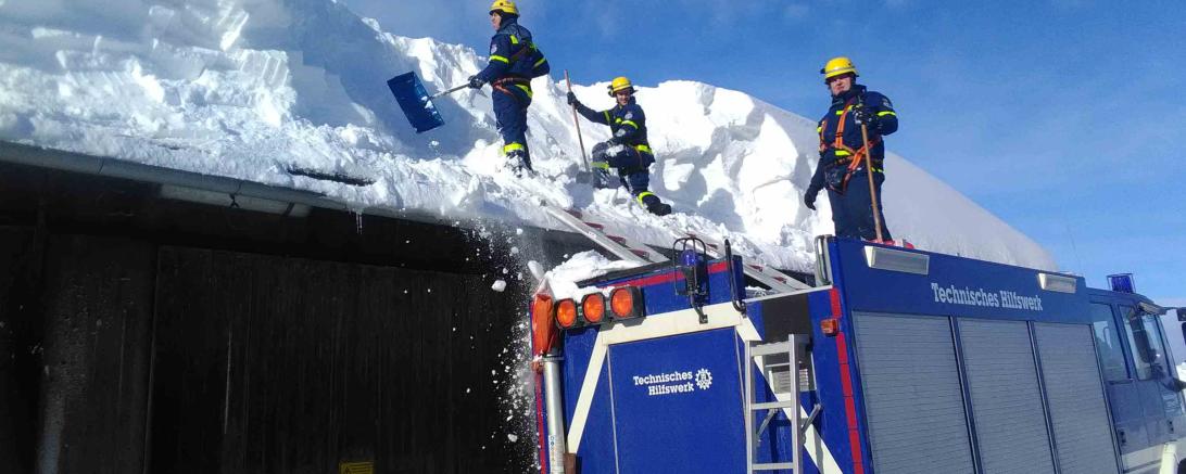 Die Männer des THWs räumen den Schnee von den Dächern