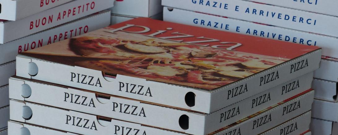Auf dem Bild sieht man Pizzaschachteln. 