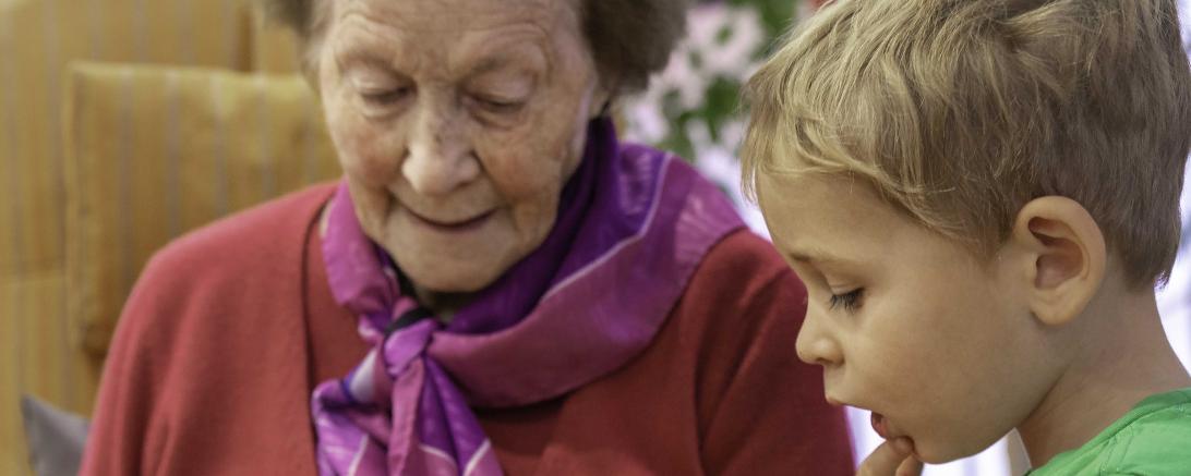 Das Bild zeigt eine Seniorin beim Vorlesen. 