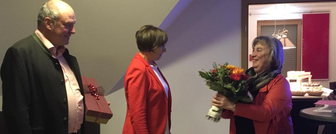 Das Bild zeigt Brigitte Kundinger-Schmidt und Peter Moll bei der Überreichung eines Blumenstraußes an Frau Friederike Rieger.