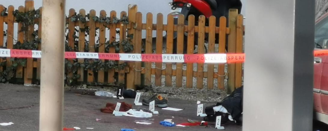 Polizeiabsperrung, dahinter Kleidungsstücke am Boden und Markierungen der Kripo