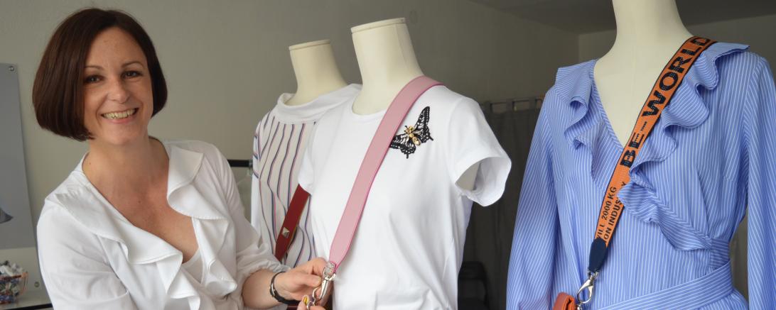 Das Bild zeigt Christine Moll. Sie dekoriert ihre Mode an Schaufensterpuppen. 