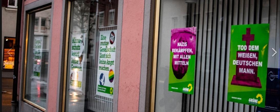 Auf zwei Plakaten ist zu lesen "Tod dem weißen, deutschen Mann" und "Nazis bekämpfen mit allen Mitteln". 