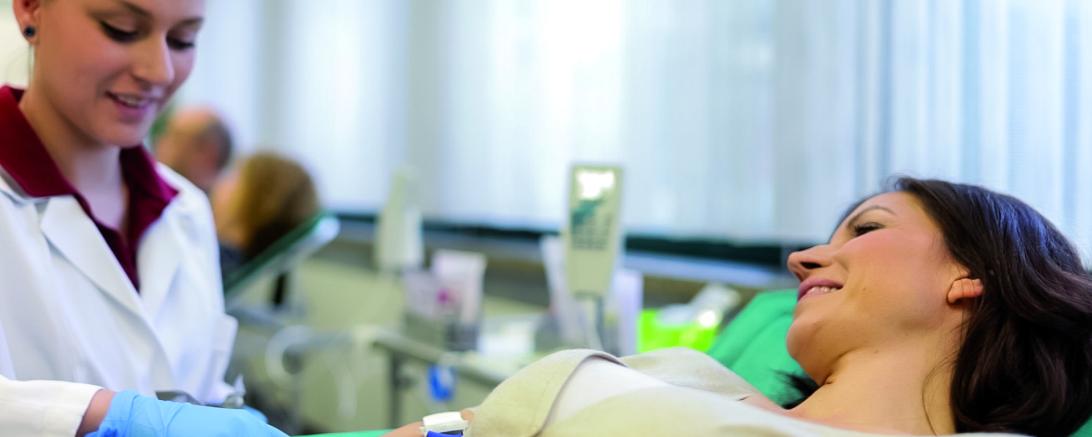 Frau auf Liege wird Blut abgenommen
