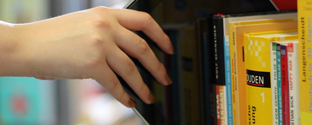 Das Bild zeigt ein Bücherregal mit einem Ipad. 