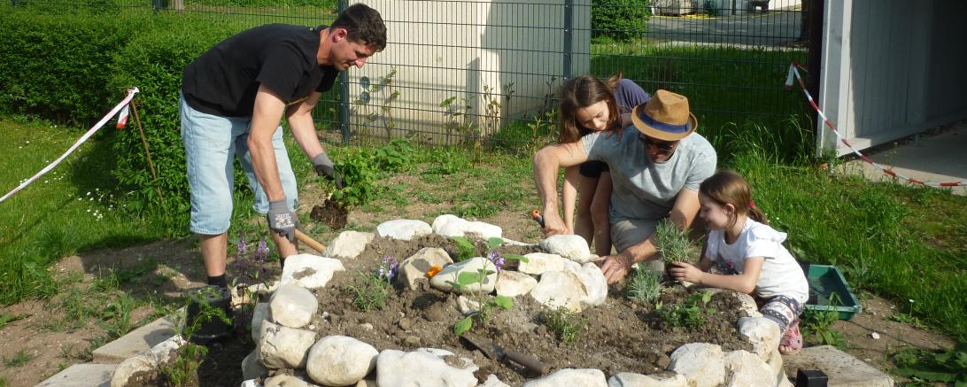 Das Bild zeigt Christian Schmid, Benjamin Zucker vom Verein "Alte Gärtnerei e.V. Tapfheim" mit Nora u. Helena bei der Bepflanzung der Kräuterschnecke.