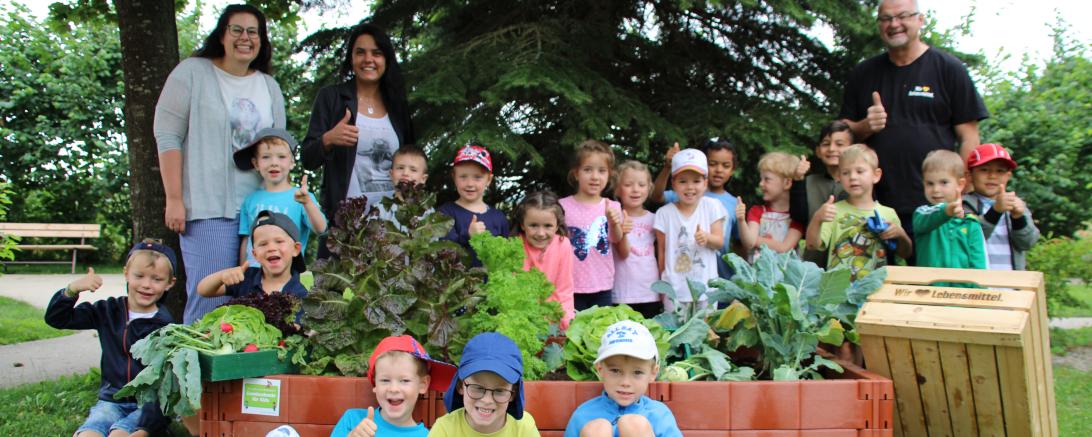 Kita-Leiterin Veronika Stoller (hinten links), Elvine Willmann (hinten, 2. von links) und Walter Willmann freuen sich mit Kindern der Kita Naseweis über die reiche Ernte.