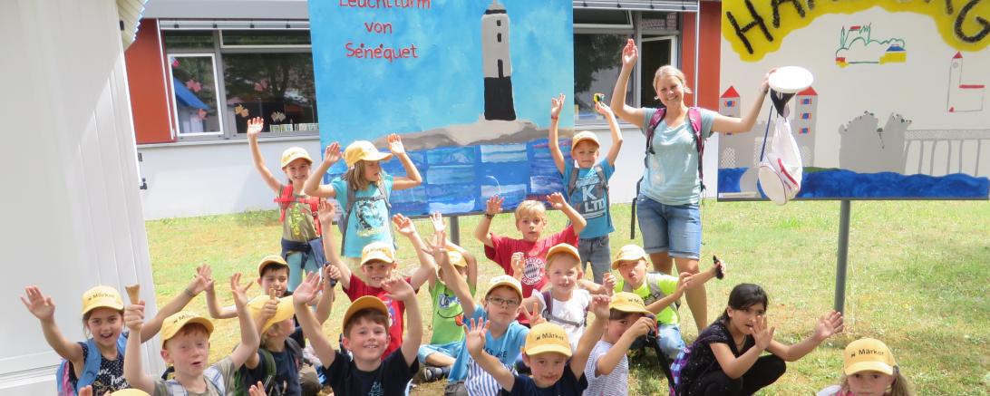 Klasse 1b nach ihrem Ausflug auf die Harburg vor ihrem Kunstwerk über den Leuchtturm von Sénéquet.