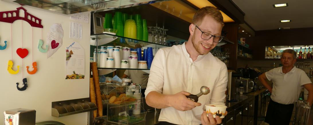 Das Bild zeigt Matthias beim Servieren des selbstgemachten Eises.
