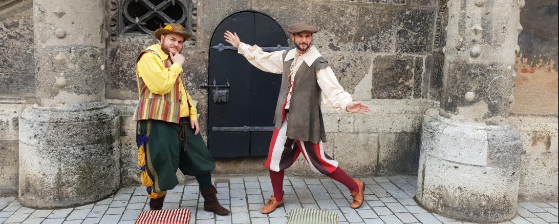 Markant sind nicht nur die Gewänder der beiden sondern auch ihre mitgeführten Schemel, auf die sie sich immer dann stellen, sobald es etwas zu erzählen gibt. 