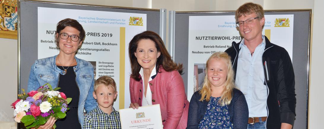 Landwirtschaftsministerin Michaela Kaniber (Mitte) übergibt den Tierwohl-Preis an Simone und Roland Naß und deren Kinder Amelie und Johannes