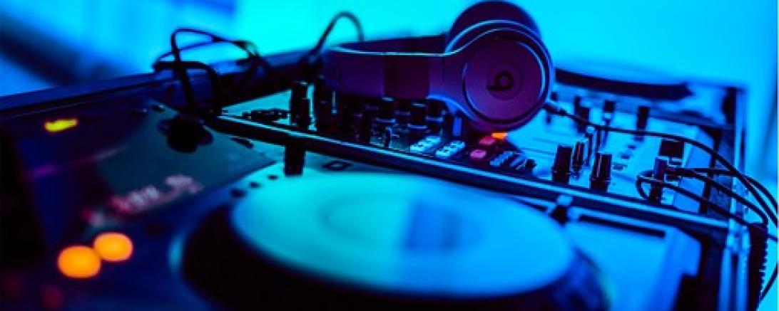 Das Bild zeigt die Schallplatten und Kopfhörer eines DJs