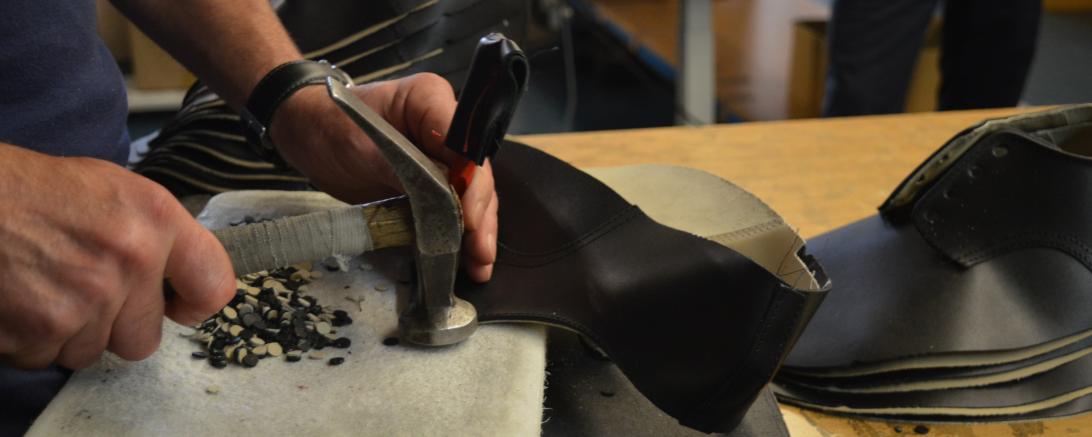 In Handarbeit werden die Ösen für die Schnürsenkel ins Leder gestanzt. 