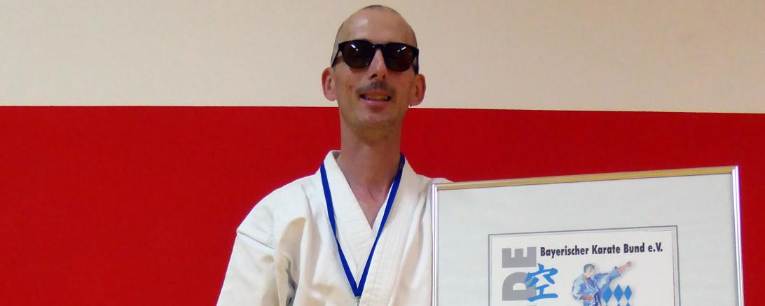 Das Bild zeigt Rene Steinhübel mit einer Urkunde