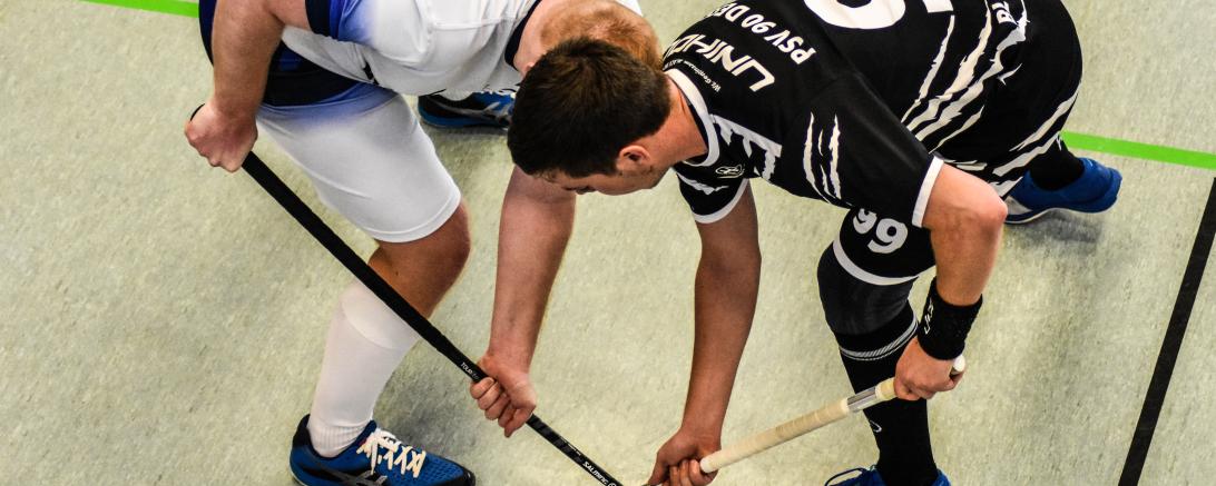 Das Bild zeigt zwei gegnerische Mannschaften beim Floorball