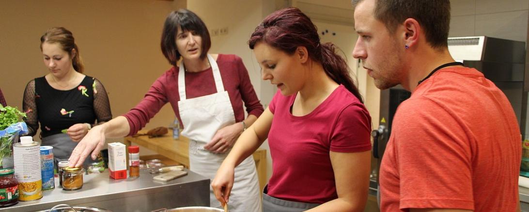 Das Bild zeigt Menschen, die miteinander kochen.